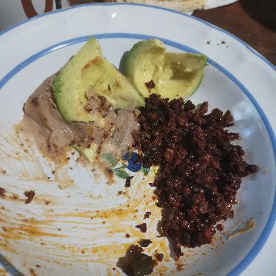 Comiendo un plato de chorizo con frijoles.